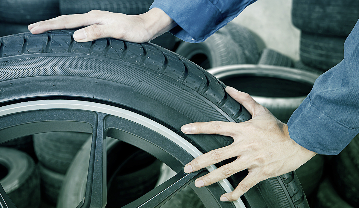 Garage worker with a wheel at Orange Tyres Uttoxeter