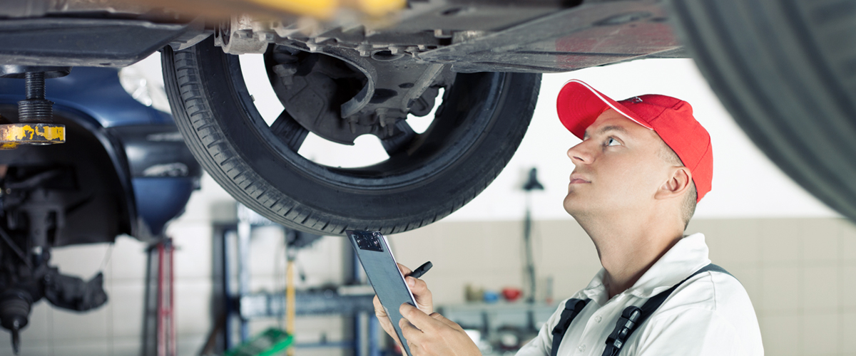 Garage worker with tyre racks and clipboard